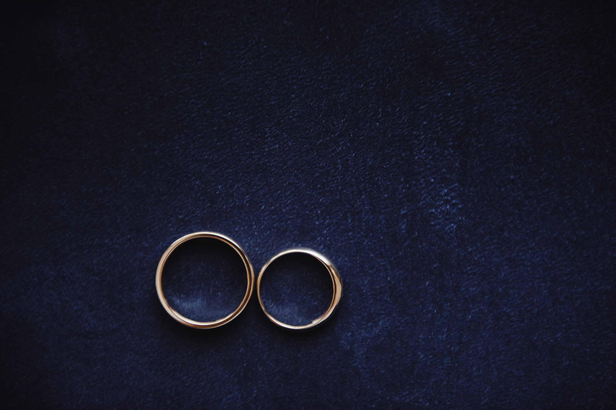 Wedding rings on a blue suede background. Wedding details.